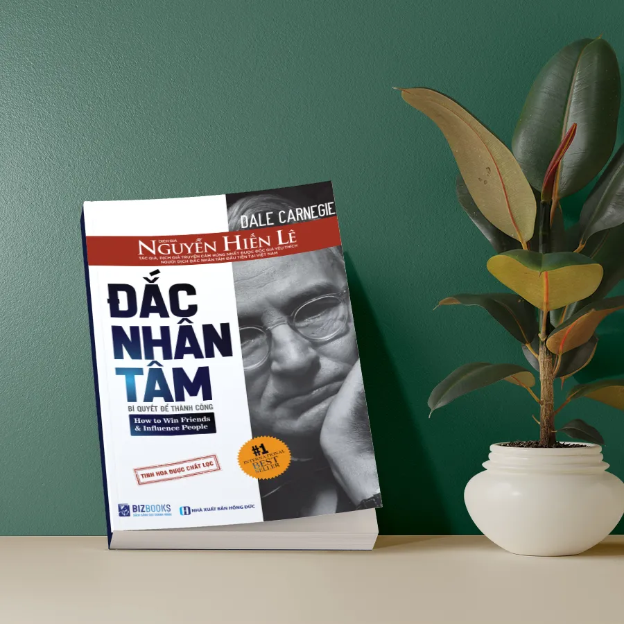 Sách Đắc Nhân Tâm đặt trên bàn làm việc, tượng trưng cho việc áp dụng bí quyết thành công vào công việc.