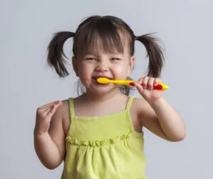 Em bé vui vẻ tập đánh răng, một thói quen tốt cho sức khỏe răng miệng từ nhỏ